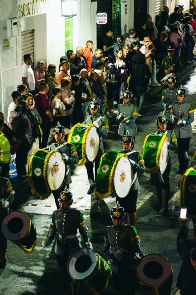 Colorful drummers in vibrant uniforms perform on the streets during a lively festival in Popayán, Cauca, Colombia.