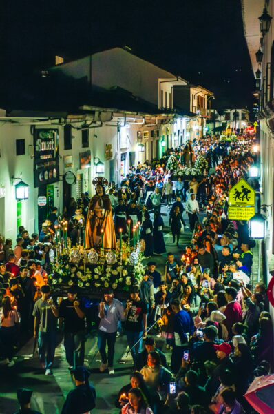 Crowds gather in the illuminated streets of Popayán, Cauca, Colombia, celebrating a vibrant nighttime procession.