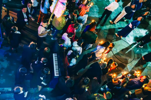 Colorfully dressed crowds gather in Popayán, Cauca, Colombia, holding candles and celebrating during a vibrant nighttime event.