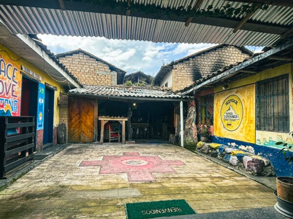 Colorful courtyard with vibrant murals and stone pathways at Refugio Terra Esperanza in La Esperanza, Ibarra, Ecuador.