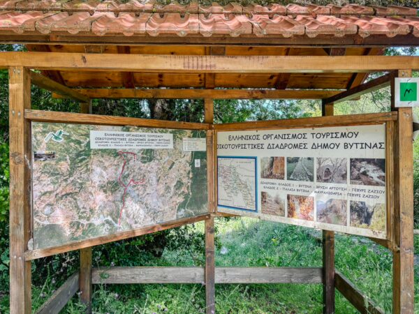 Informational signs display maps and details about outdoor activities in Vytina, surrounded by lush greenery in Arcadia, Greece.