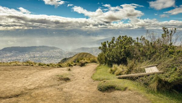 Pichincha Volcano features a scenic path with lush greenery and stunning city views below, showcasing Ecuador's natural beauty.