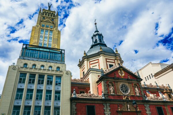 Stunning architecture contrasts with vibrant colors, showcasing historic and modern buildings in Madrid, Spain.