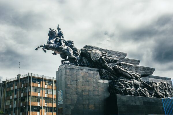 Majestic Simon Bolivar Monument in Quito, Ecuador, showcases intricate bronze details against a dramatic cloudy sky.