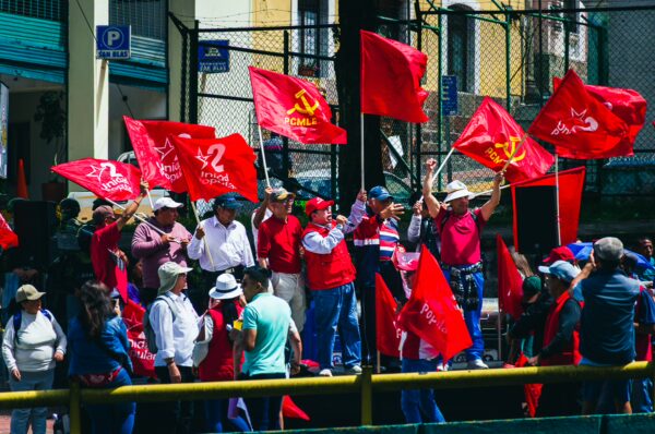 Red flags wave as supporters celebrate International Workers' Day during a lively parade in Quito, Ecuador.
