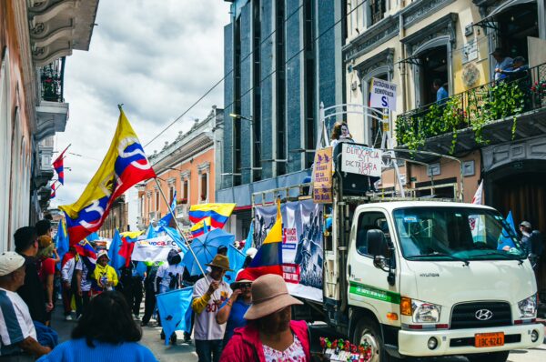 Colorful flags wave in a bustling street during the International Workers' Day parade in Quito, Ecuador, 2026.
