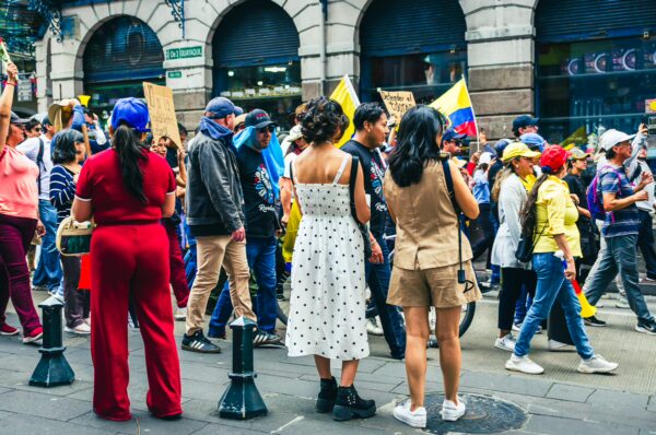 International Workers' Day parade in Quito, Ecuador, features a vibrant crowd with colorful banners and diverse attire.