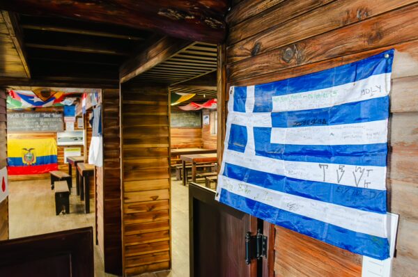 Colorful banners and a Greek flag hang inside the cozy José Rivas Refuge, overlooking Mount Cotopaxi in Ecuador.