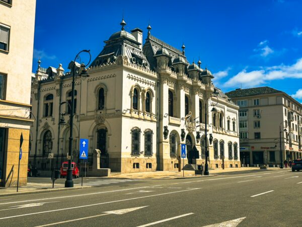 Administrative Palace of Craiova features elegant architecture and ornate details against a clear blue sky, showcasing Romania's cultural heritage.