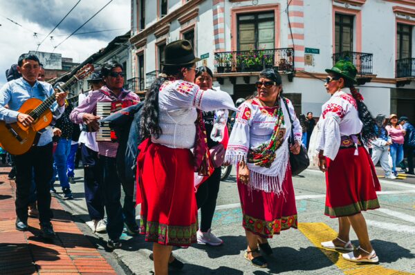 Celebrants in traditional attire dance and play music during the International Workers' Day parade in Quito, Ecuador.
