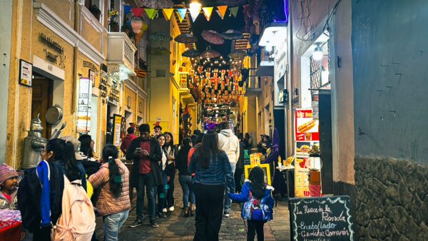 Vibrant La Ronda street in Quito features colorful decorations and bustling crowds enjoying local shops and eateries.