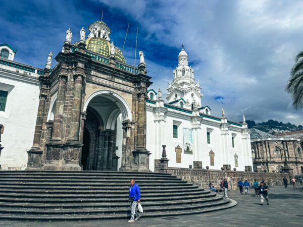 Stunning architecture of the San Francisco Church in Quito, Ecuador, featuring ornate details and vibrant sky.