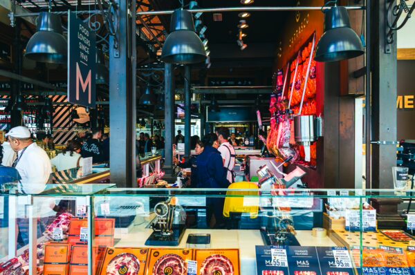 Vibrant stalls featuring gourmet products and bustling crowds in Mercado de San Miguel, Madrid, Spain, showcase local culinary delights.