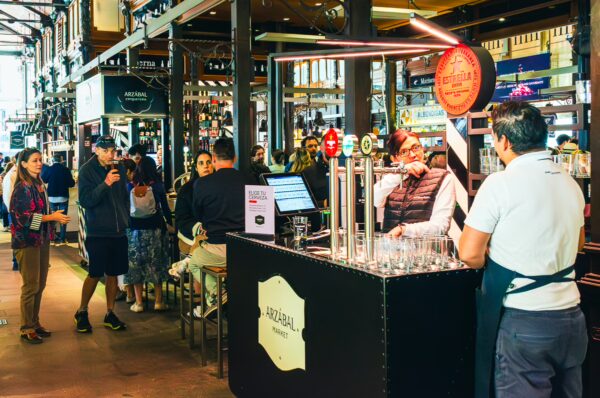 Mercado de San Miguel in Madrid, Spain, bustling with visitors enjoying food stalls and a vibrant ambiance.