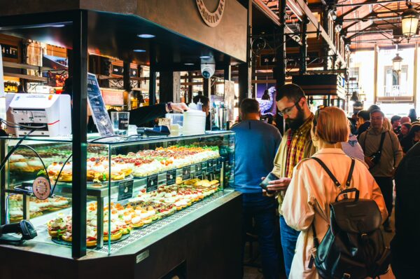 Vibrant food display at Mercado de San Miguel, Madrid, with patrons enjoying tapas and a lively atmosphere.