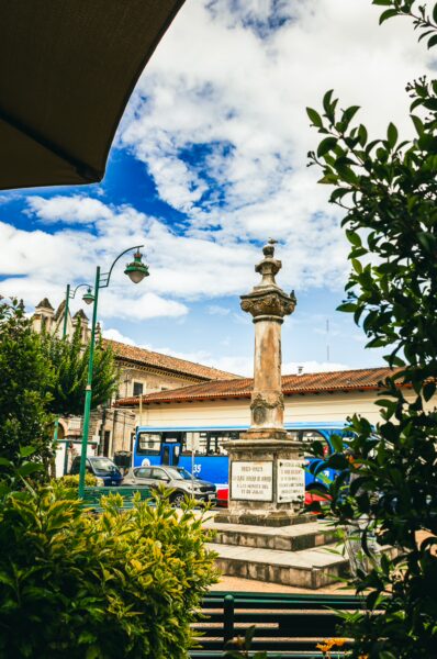 San Agustin Park showcases a historic monument surrounded by lush greenery and vibrant blue skies in Ibarra, Ecuador.