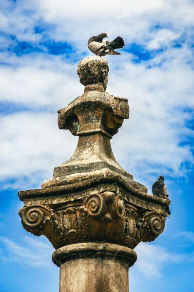 Monumento Abdon Calderon in Ibarra, Ecuador, features a detailed column topped by birds against a bright blue sky.