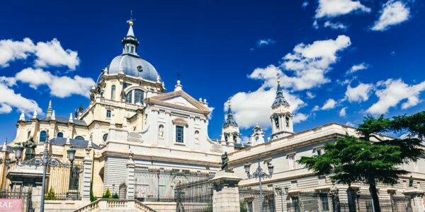 Catedral de Santa María showcases stunning architecture with a blue sky backdrop in Madrid, Spain, highlighting its elegant dome and intricate details.