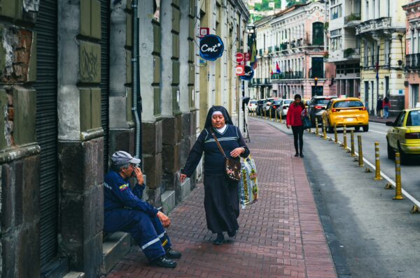 Busy street scene in Guayaquil, Quito, Ecuador, showcasing pedestrians, taxis, and vibrant colonial architecture.