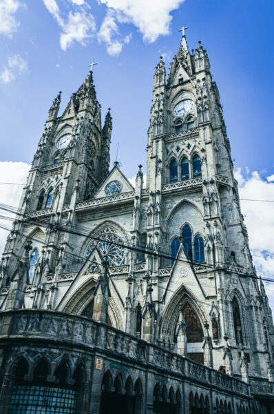 Basilica del Voto Nacional showcases stunning Gothic architecture under a bright blue sky in Quito, Ecuador.