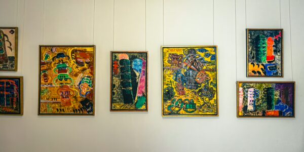Vibrant abstract paintings hang on the walls of the Ion Tuculescu Art Museum in Craiova, Romania, showcasing bold colors and intricate designs.