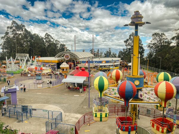 Brightly colored attractions and rides at Vulqano Park, set against the backdrop of Pichincha Volcano in Ecuador.