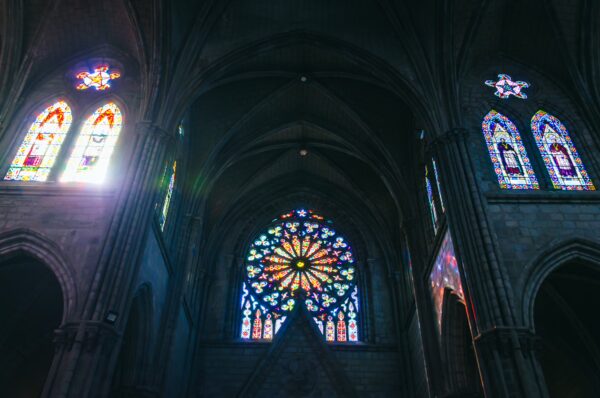 Vibrant stained glass windows illuminate the interior of Basilica del Voto Nacional in Quito, Ecuador.