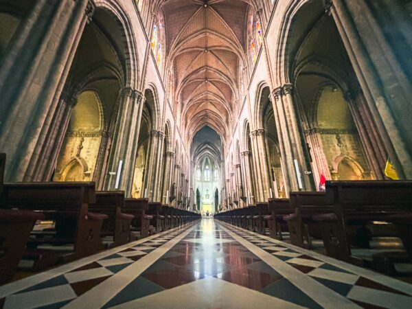 Majestic interior of Basilica del Voto Nacional, showcasing intricate architecture and vibrant colors in Quito, Ecuador.