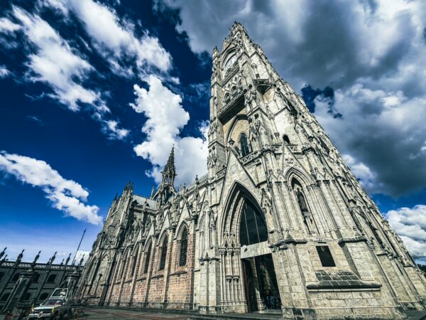 Basilica del Voto Nacional's intricate Gothic architecture towers against a dramatic sky in Quito, Ecuador.