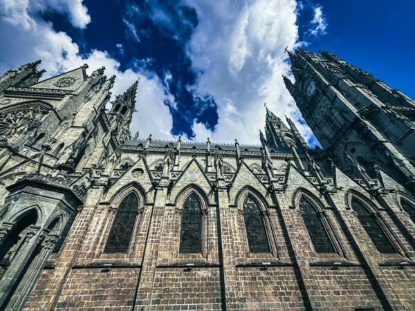 Majestic Basilica del Voto Nacional with intricate Gothic architecture and striking blue sky in Quito, Ecuador.