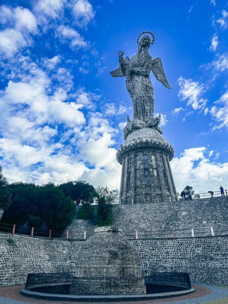 Ecuador's stunning landscape features the towering Virgin of El Panecillo statue against a vibrant blue sky in Quito.