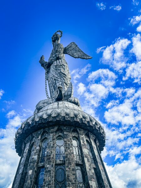Virgen de Quito statue rises majestically against a blue sky, capturing the essence of Quito, Ecuador.