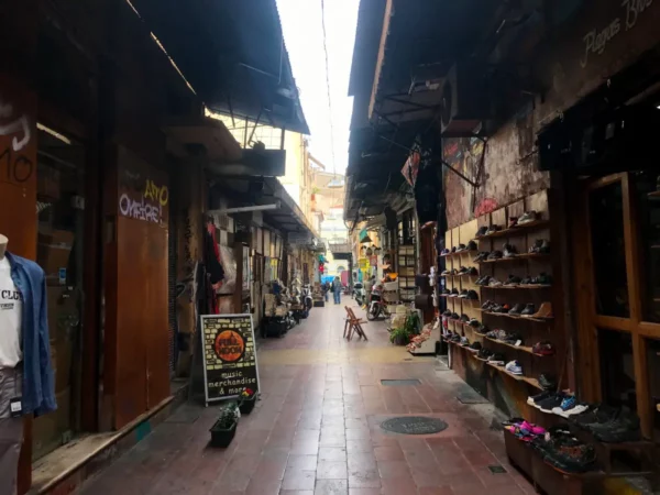 Charming pedestrian street lined with shops and vibrant displays in Chalkis, featuring footwear and local merchandise.