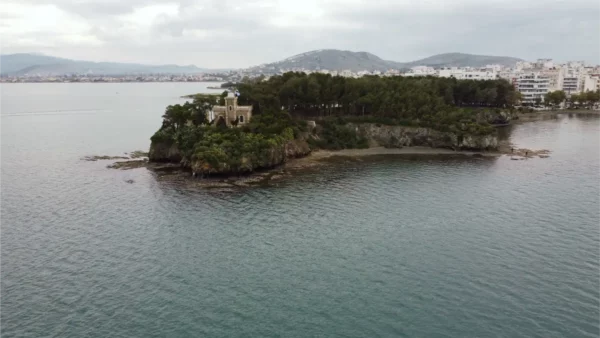 Chalkis features a small island with lush greenery and a distinctive building along the tranquil waters of Euboea, Greece.