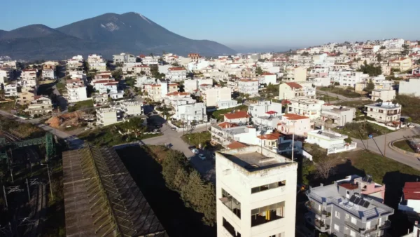 Vibrant residential landscape of Chalkis, Euboea, Greece, featuring hills and a mix of modern architecture under clear blue skies.