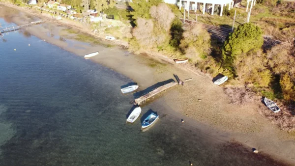 Serene boats rest near the shore at Chalkis, Euboea, Greece, with a peaceful landscape and clear water reflecting the sky.