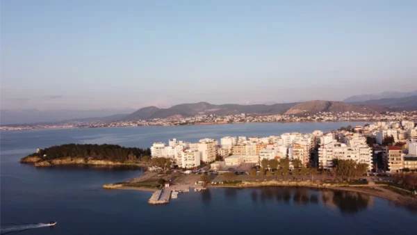 Chalkis waterfront features modern buildings and a scenic coastline with hills in the background, capturing the beauty of Euboea, Greece.