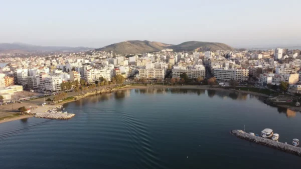 Chalkis features a serene waterfront, surrounded by modern buildings and distant hills, reflecting on calm waters in Euboea, Greece.