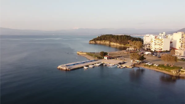 Serene waterfront views in Chalkis, Euboea, Greece, showcasing calm waters and a small marina with boats.