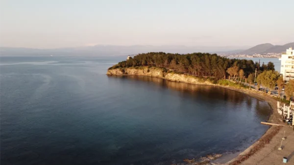 Tranquil waters of Chalkis in Euboea, Greece, framed by a coastal landscape and lush greenery at sunset.