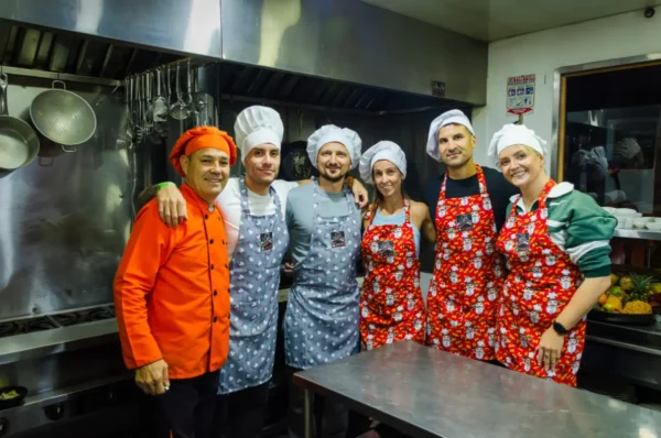Cooking class chefs in aprons and hats, posing in a kitchen in Salento, Colombia.
