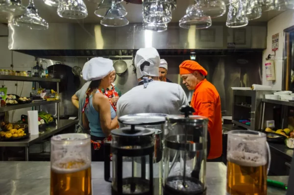 Cooking class in Salento, Colombia: chefs in white hats prepare food in a professional kitchen.