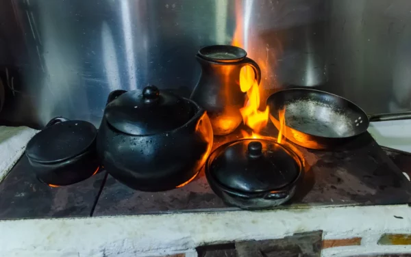 Open fire with black cooking pots and a copper kettle during a cooking class in Salento, Colombia