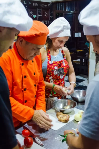 Cooking class in Salento, Colombia: chefs and students in aprons prepare food at a kitchen table.