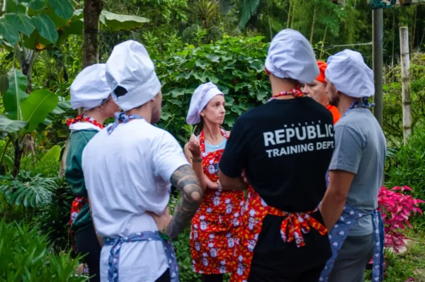 Cooking class in Salento, Colombia: chefs in garden teaching; shirt reads “REPUBLIC TRAINING DEPT”.