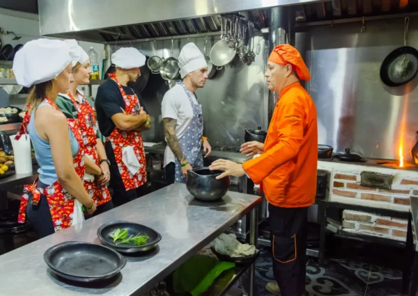 Cooking class kitchen in Salento, Colombia, chefs and students cook at a flaming stove