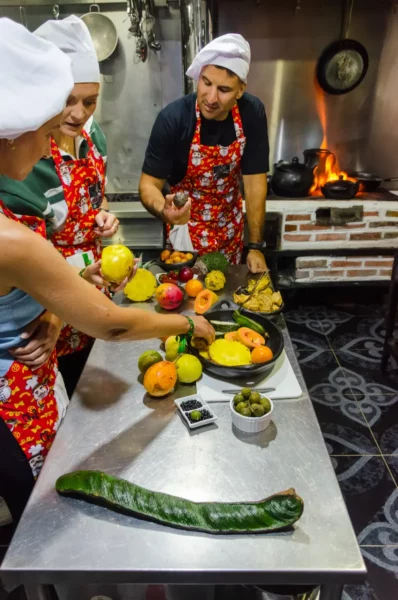 Cooking class in Salento, Colombia: chefs and guests prep colorful vegetables by a wood-fired stove
